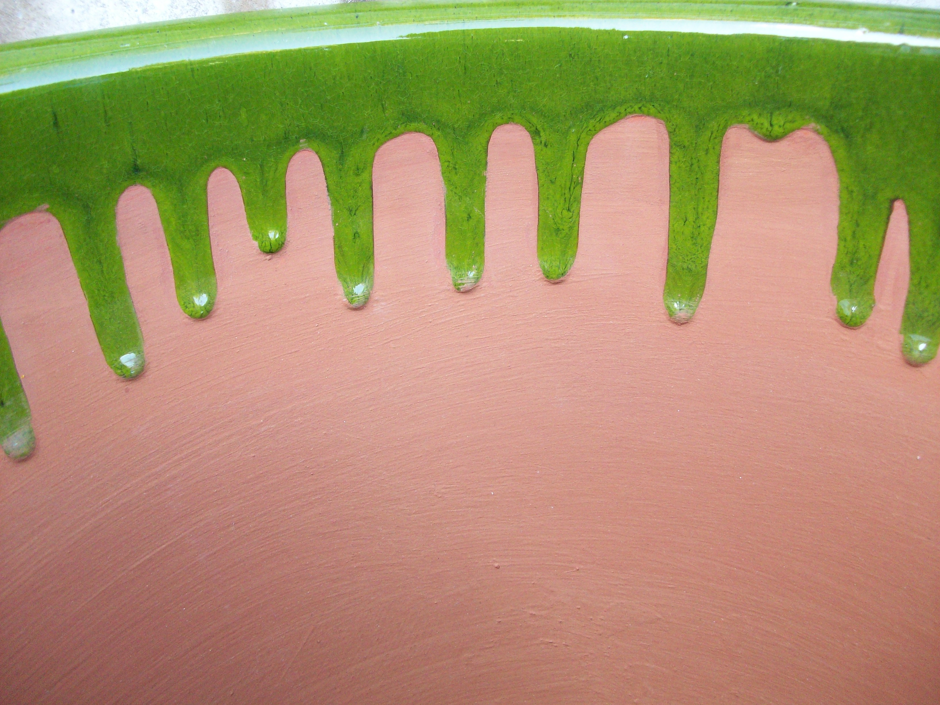 green paint drips on terracotta