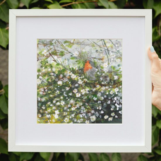 Robin by Claire Leggett. Two hands holding a mocked up framed image of Robin - an original acrylic painting by Claire Leggett